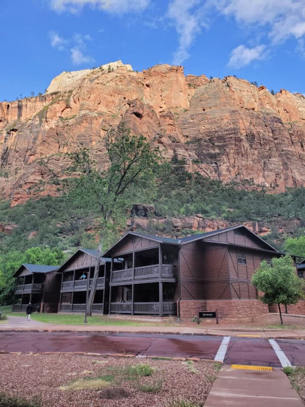 https://www.parkrangerjohn.com/wp-content/uploads/2022/01/Zion-Lodge-with-Sandstone-Cliffs-behind-it-utah.jpg