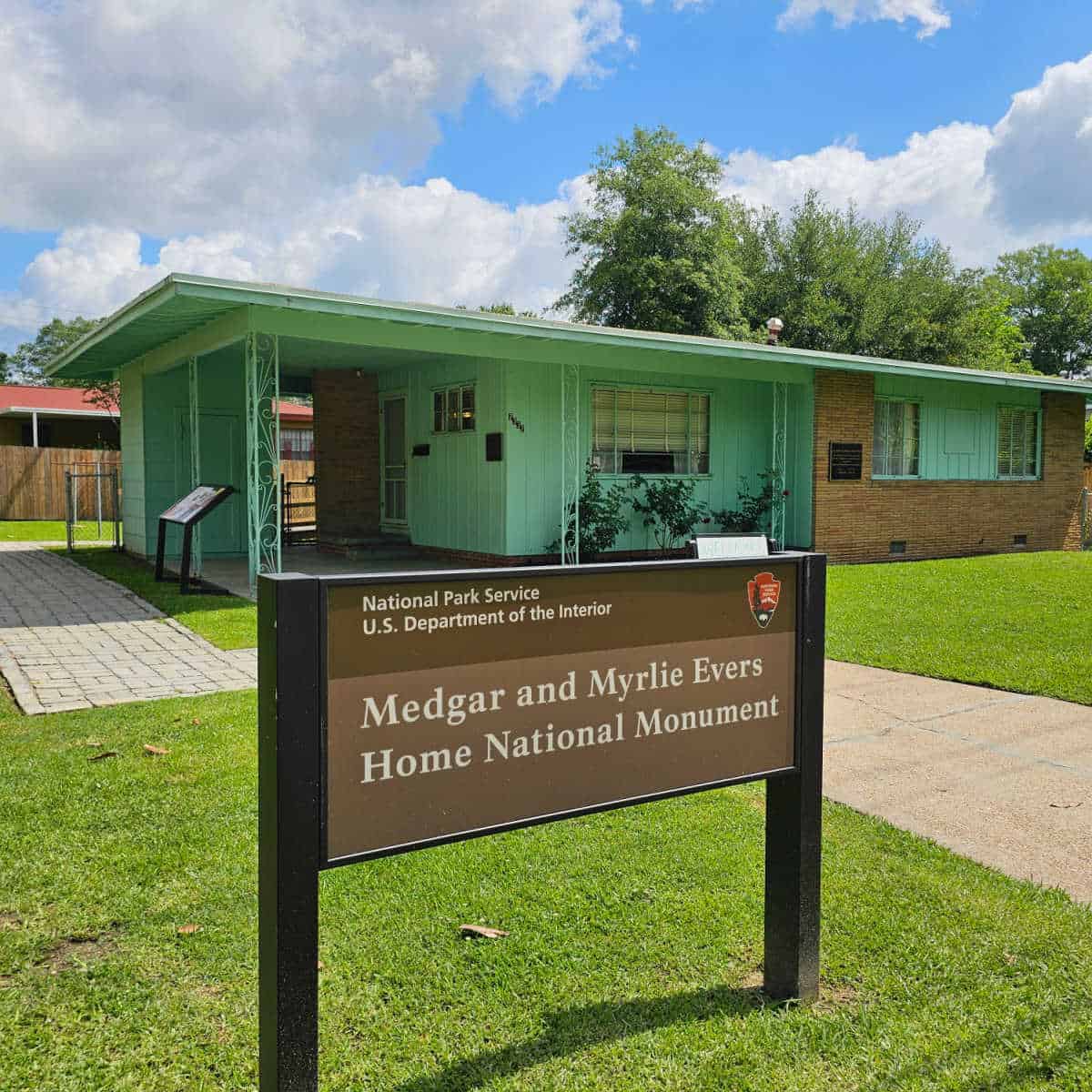 Medgar and Myrlie Evers Home National Monument sign in front of a green single story house