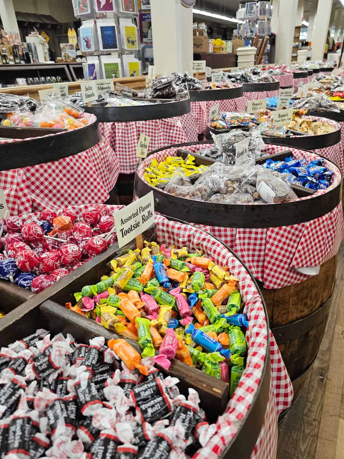 Barrels of candy with tootsie rolls and other brightly packaged candy