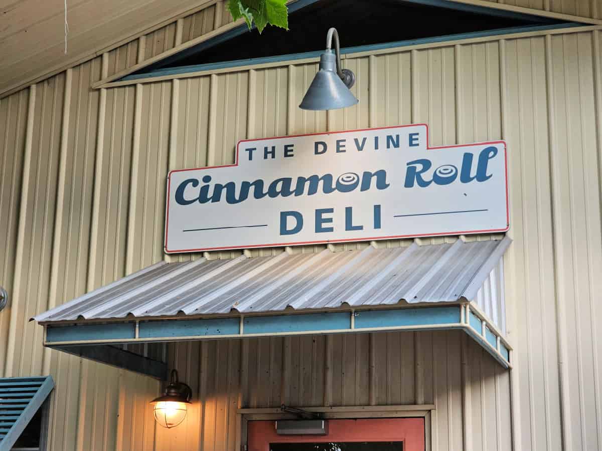 The Devine Cinnamon roll Deli sign over an entrance door