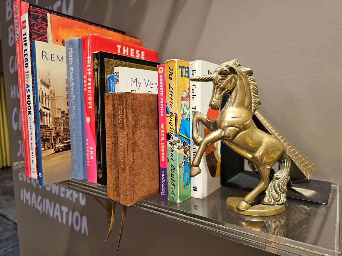 Unicorn book end holding up books on a shelf